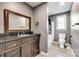 Gray bathroom with dark vanity, large mirror, and shower/bath combo at 107 Maurice St, Monroe, NC 28112