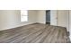 Bedroom features wood-look flooring, fresh paint, and natural light from a large window at 107 Maurice St, Monroe, NC 28112