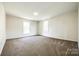Spacious bedroom featuring neutral walls, plush carpeting, and abundant natural light from two windows at 107 Maurice St, Monroe, NC 28112