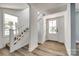 Bright foyer with wood-look flooring, staircase, and a white front door at 107 Maurice St, Monroe, NC 28112