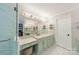 Well-lit bathroom vanity with light green cabinets, quartz countertops, and ample lighting at 108 Tall Oak Dr, Mooresville, NC 28117