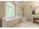 Elegant bathroom featuring a soaking tub with a large window and a glass enclosed shower at 108 Tall Oak Dr, Mooresville, NC 28117