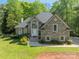 Charming home features a brick facade, arched window above entry, and lush landscaping at 108 Tall Oak Dr, Mooresville, NC 28117