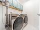 Bright laundry room featuring front loading washer and dryer set and blue cabinets above at 108 Tall Oak Dr, Mooresville, NC 28117