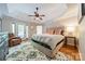 Spacious main bedroom with trey ceilings, wood floors, a ceiling fan, and a private balcony at 108 Tall Oak Dr, Mooresville, NC 28117