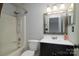 Bathroom featuring a shower-tub combo and dark vanity with a framed mirror, maximizing space at 11163 Harrowfield Rd # 8198, Charlotte, NC 28226