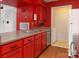 Modern kitchen features vibrant red cabinetry and stainless steel appliances, creating a bold, updated look at 11163 Harrowfield Rd # 8198, Charlotte, NC 28226