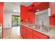 Bright, updated kitchen with stainless steel sink, red cabinets, and glass doors that let in natural light at 11163 Harrowfield Rd # 8198, Charlotte, NC 28226