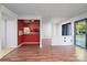 Open concept living space featuring wood floors, a red accent wall, and sliding glass doors to the balcony at 11163 Harrowfield Rd # 8198, Charlotte, NC 28226