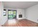 The living room features a decorative fireplace, wood floors, and sliding doors which lead to a balcony at 11163 Harrowfield Rd # 8198, Charlotte, NC 28226