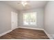Bedroom featuring a window with blinds, wood-look floors, and white trim at 1143 N College Ave, Newton, NC 28658