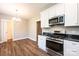 This open-concept kitchen features stainless appliances, gas range, and granite countertops at 1143 N College Ave, Newton, NC 28658