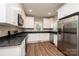 Modern kitchen features stainless steel appliances, white cabinetry, and granite counters at 1143 N College Ave, Newton, NC 28658