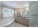 Bright bathroom with double sinks, a jetted tub, and shuttered windows at 1228 Quiet Acres Rd, Rock Hill, SC 29732