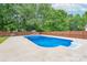 Inviting in-ground pool is surrounded by a patio and lush, green trees at 1228 Quiet Acres Rd, Rock Hill, SC 29732