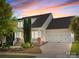 Charming two-story home with a two-car garage and lovely landscaped front yard at sunset at 12614 Robert Walker Dr, Davidson, NC 28036