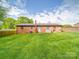 The backyard of the brick house features a well-maintained lawn and a wooden fence at 1315 Holshouser Rd, Rockwell, NC 28138