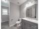 Bathroom has a gray vanity with double sinks and modern fixtures and wood-look floors at 1315 Holshouser Rd, Rockwell, NC 28138