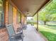 Inviting covered porch with rocking chairs offering a relaxing outdoor space with views of the landscaped yard at 1315 Holshouser Rd, Rockwell, NC 28138