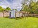 Metal shed in the yard featuring a roll-up door and a wooden frame at 1315 Holshouser Rd, Rockwell, NC 28138