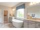 Luxurious bathroom with a freestanding tub, double vanities, and a large window at 13304 Chopin Ridge Dr, Huntersville, NC 28078