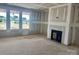Living room with fireplace and drywall; bright natural light streams through large windows at 13304 Chopin Ridge Dr, Huntersville, NC 28078