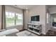 Cozy living room with natural light, featuring a TV and decorative shelving unit at 13304 Chopin Ridge Dr, Huntersville, NC 28078