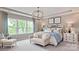 Serene main bedroom suite featuring a large window, a seating area, and elegant decor at 13304 Chopin Ridge Dr, Huntersville, NC 28078