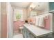 Cozy pink bathroom featuring tile, vanity, window, and shower with curtain at 1331 Mccorkle Rd, Charlotte, NC 28214