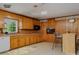 This is a spacious kitchen with hardwood cabinets, white appliances, bar stool seating and hardwood floors at 1331 Mccorkle Rd, Charlotte, NC 28214