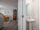 Hallway view of dining area with wood-look floors, transitioning into a small powder room with pedestal sink at 1347 Mifflin Ln, Dallas, NC 28034