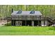 Back exterior of a charming home with a spacious deck and lush green lawn at 143 Ross Rd, Mooresville, NC 28117