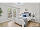 Cozy bedroom featuring multiple windows, hardwood floors, and neutral-colored decor and furniture at 143 Ross Rd, Mooresville, NC 28117