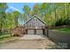 Beautiful home exterior with a large deck and garage access, nestled in a wooded setting at 143 Ross Rd, Mooresville, NC 28117