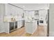 Modern white kitchen featuring stainless steel appliances, center island, and beverage fridge at 143 Ross Rd, Mooresville, NC 28117