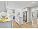 Modern kitchen with stainless steel appliances, white cabinets, and an island with quartz countertops at 143 Ross Rd, Mooresville, NC 28117