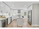 Bright, all-white kitchen featuring stainless steel appliances and a center island for food preparation at 143 Ross Rd, Mooresville, NC 28117