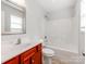 Bathroom with cherry vanity, white countertops, tub, and shower at 15 Wright St, Rock Hill, SC 29730