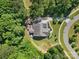 Aerial view of a home with an expansive deck surrounded by lush greenery and a curved driveway at 15210 Pavilion Valley Cir, Huntersville, NC 28078