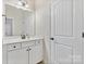 Neutral bathroom with single vanity, white door, and modern finishes at 15210 Pavilion Valley Cir, Huntersville, NC 28078