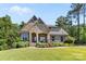 Charming brick home boasting lovely landscaping, a round window, and a cozy front porch at 15210 Pavilion Valley Cir, Huntersville, NC 28078