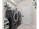 Laundry room with side-by-side black washer and dryer and storage shelving at 15210 Pavilion Valley Cir, Huntersville, NC 28078