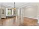 Open-concept living space with hardwood floors, large windows, and decorative shelving at 15210 Pavilion Valley Cir, Huntersville, NC 28078