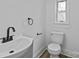 Updated bathroom featuring a modern vanity, fixtures, and a toilet next to the window at 1601 Gambia St, Charlotte, NC 28208