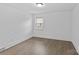 A bright bedroom features a window letting in natural light and hardwood flooring throughout the room at 1601 Gambia St, Charlotte, NC 28208