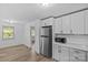 Bright kitchen boasts stainless steel appliances, white cabinets, and wood-look flooring at 1601 Gambia St, Charlotte, NC 28208