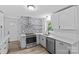 Beautifully renovated kitchen with white cabinets, quartz countertops, and stainless steel appliances at 1601 Gambia St, Charlotte, NC 28208
