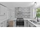 Well-lit kitchen with modern appliances, gray cabinets, stainless steel fixtures, and a decorative backsplash at 1601 Gambia St, Charlotte, NC 28208