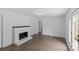 Bright living room with a painted brick fireplace, hardwood floors, and large windows at 1601 Gambia St, Charlotte, NC 28208