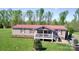 Single-story home featuring a red roof and inviting front porch, nestled within a vast green lawn at 161 Hickory Nut Dr, Statesville, NC 28677